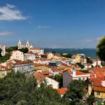 brown and white concrete houses near green trees under blue sky during daytime sao